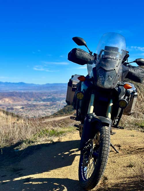 Paul's motorcycle parked with curved and mountainous landscape in background