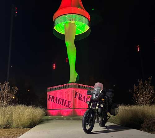 Paul's motorcycle parked in front of a large replica of the leg lamp from the movie a christmas story