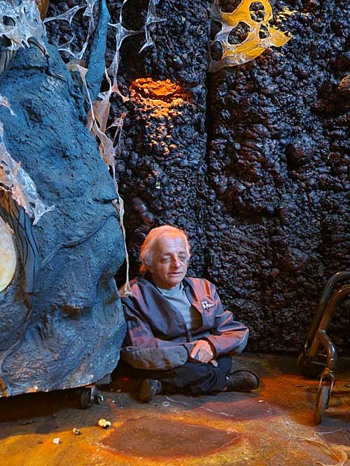 disabled actor sits in crevasse of rock wall on the movie set.