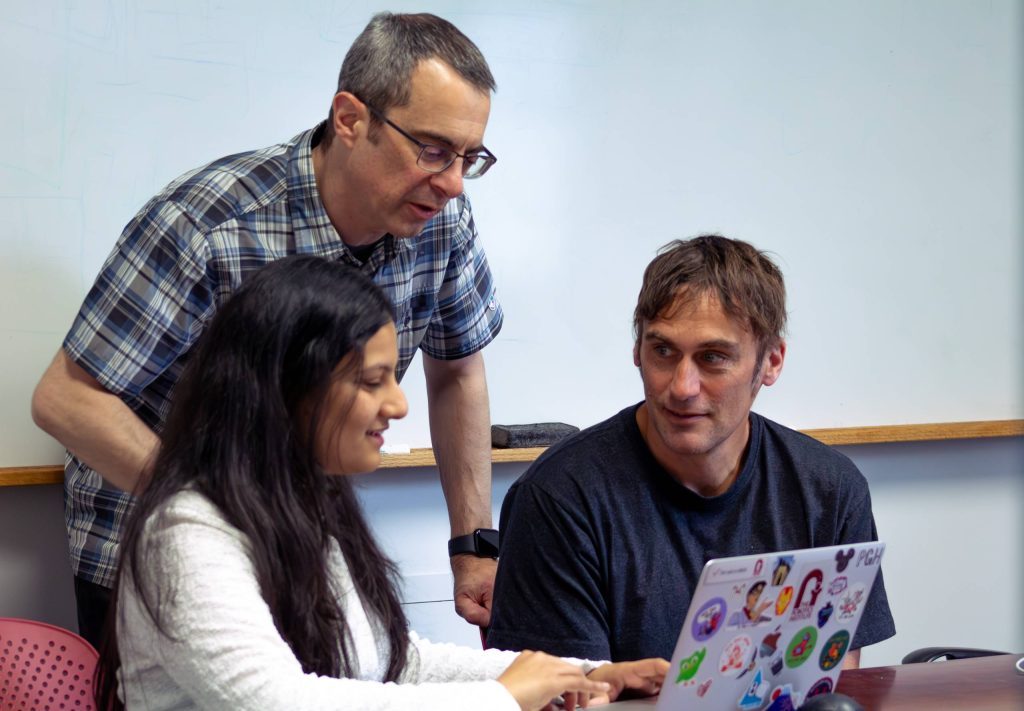 CMU researchers Peya Mowar, Jeff Bigham, and Aaron Steinfield collaborate around a laptop.